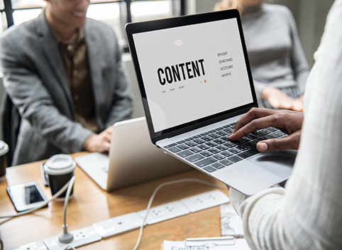 Someone is holding laptop while writing a content on keyboard
